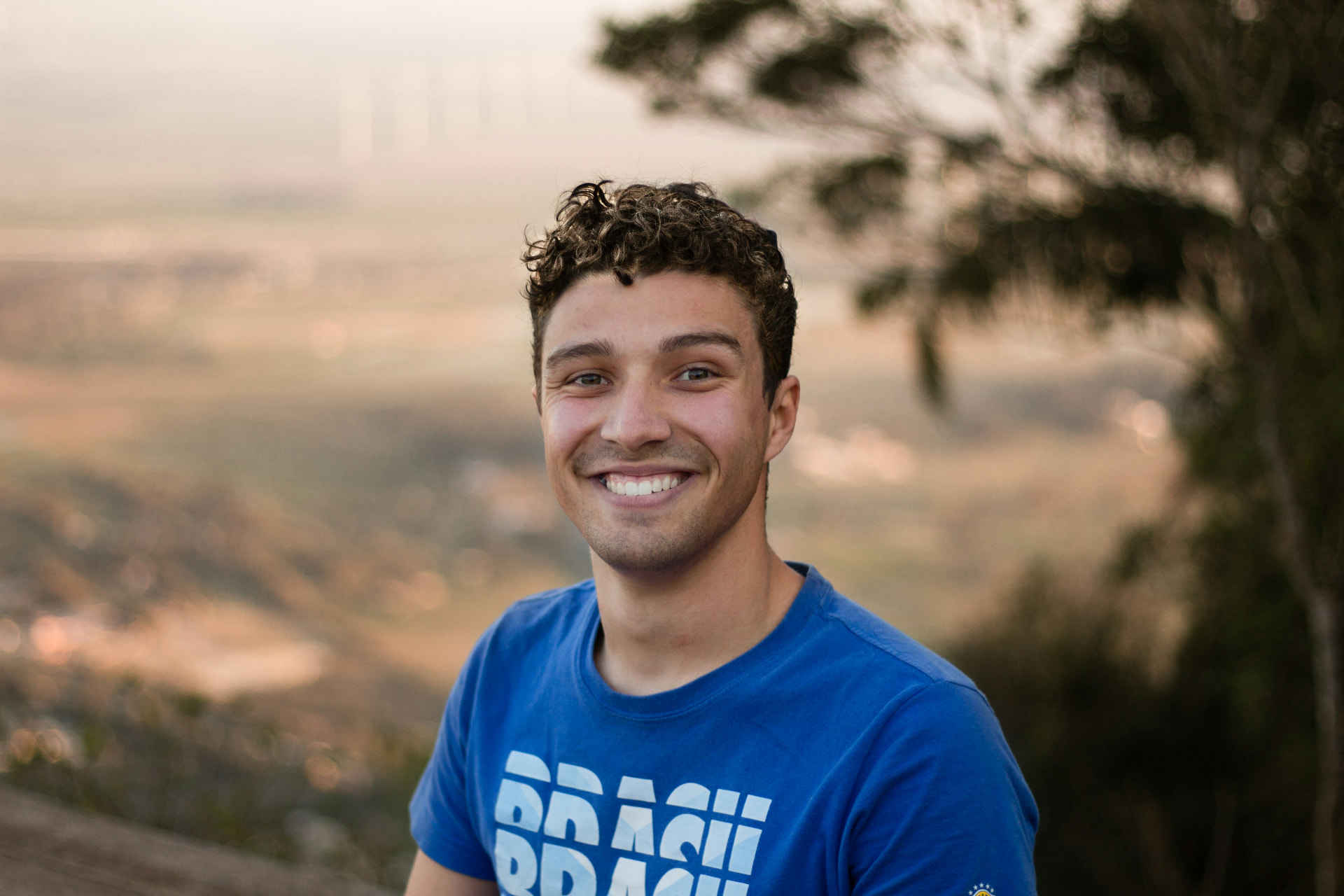 Portrait d'un jeune homme souriant en extérieur au coucher du soleil